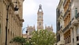 A historic building with a clock tower, ornate balconies, and classical architecture.
