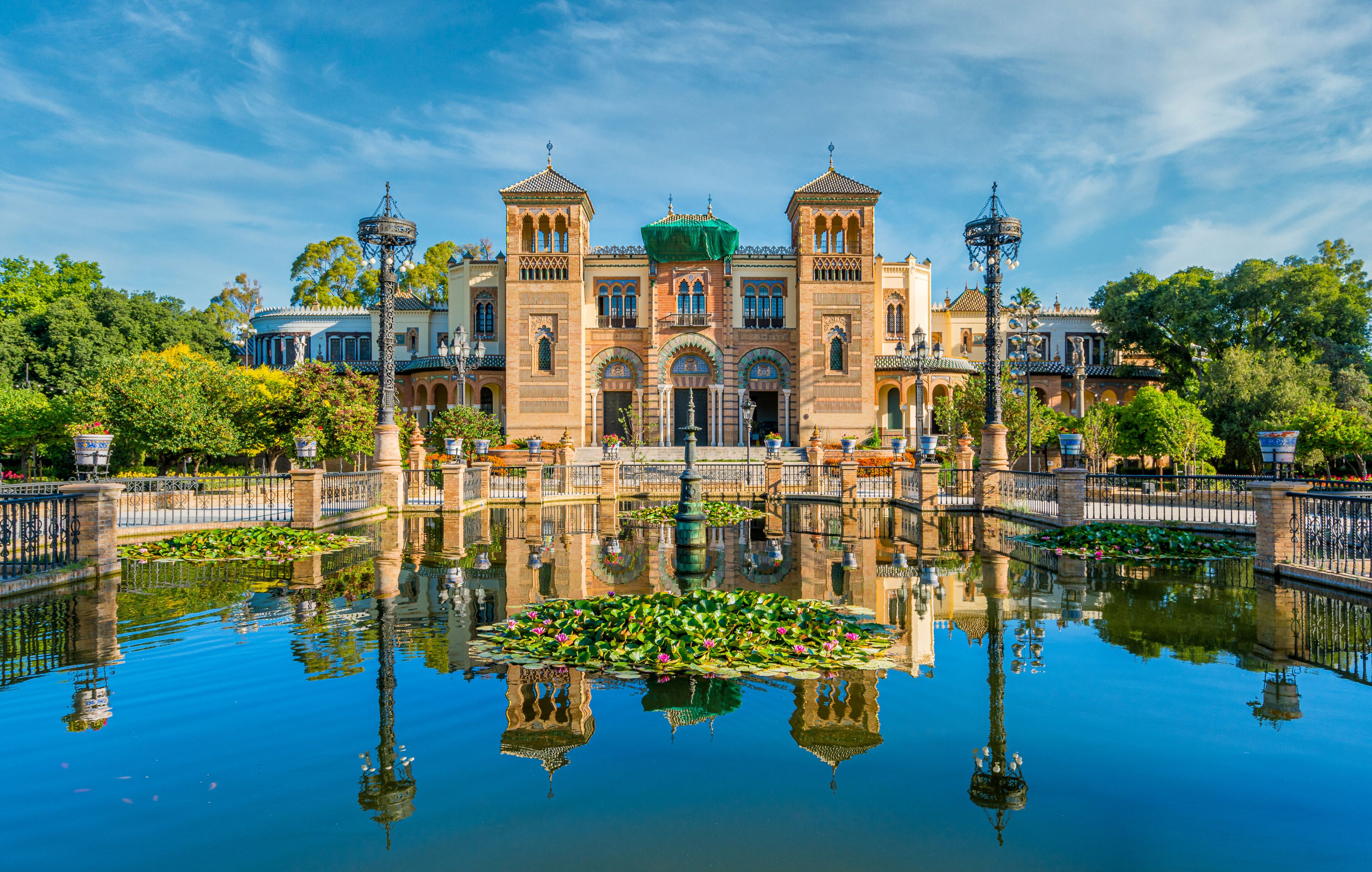 Museum of Popular Arts and Traditions reflecting in the near fountain in Seville, Andalusia, Spain.