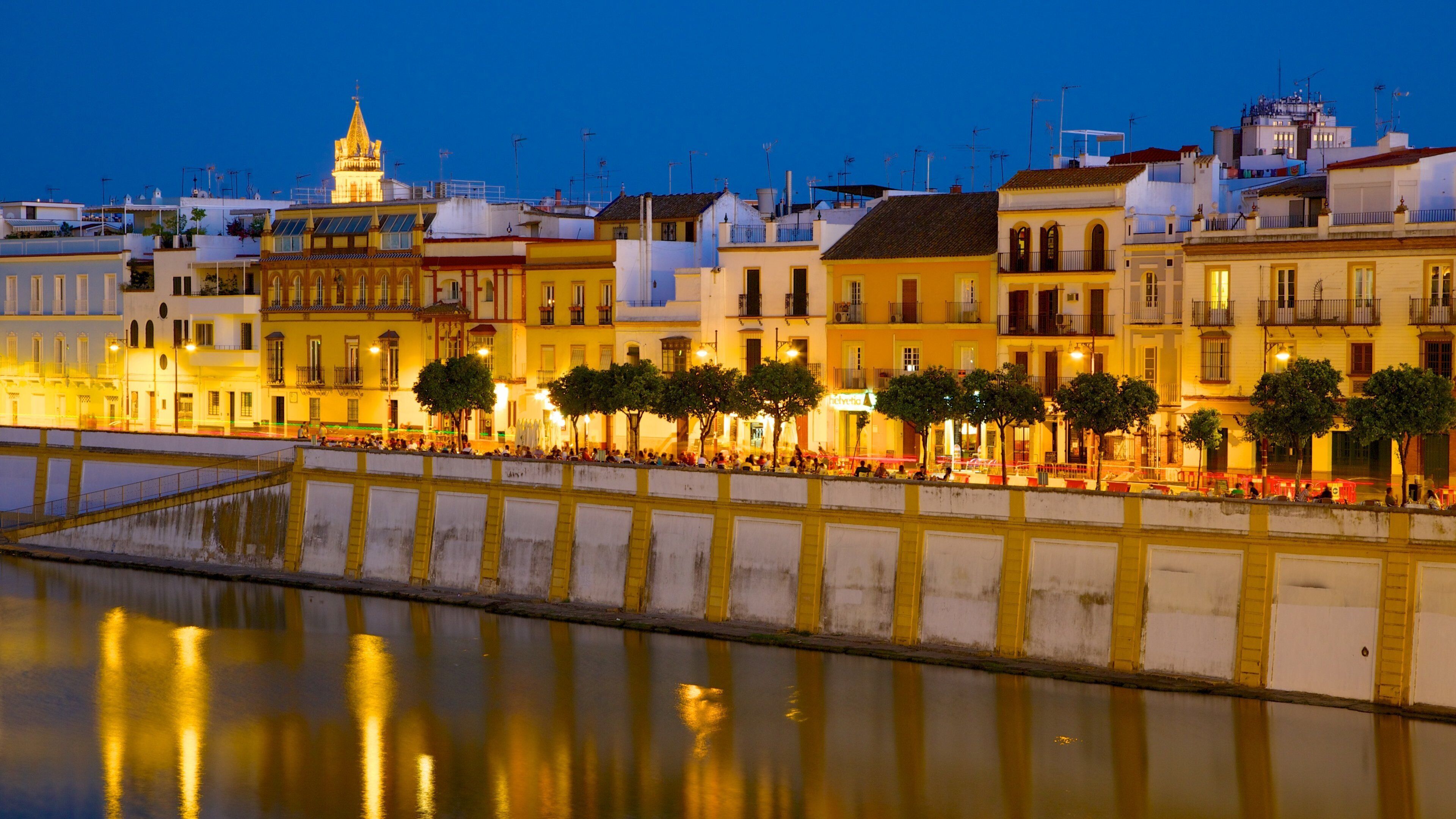 Triana Bridge which includes night scenes, a city and a river or creek