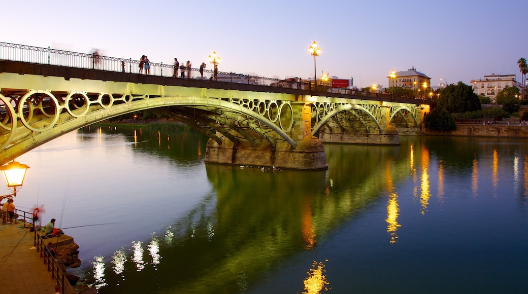 Triana Bridge which includes night scenes, a bridge and a river or creek