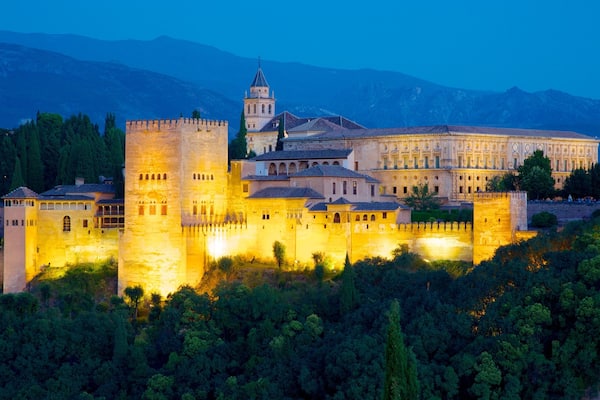A historic fortress with a prominent tower and a large building with ornate architecture.