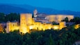 A historic fortress with a prominent tower and a large building with ornate architecture.