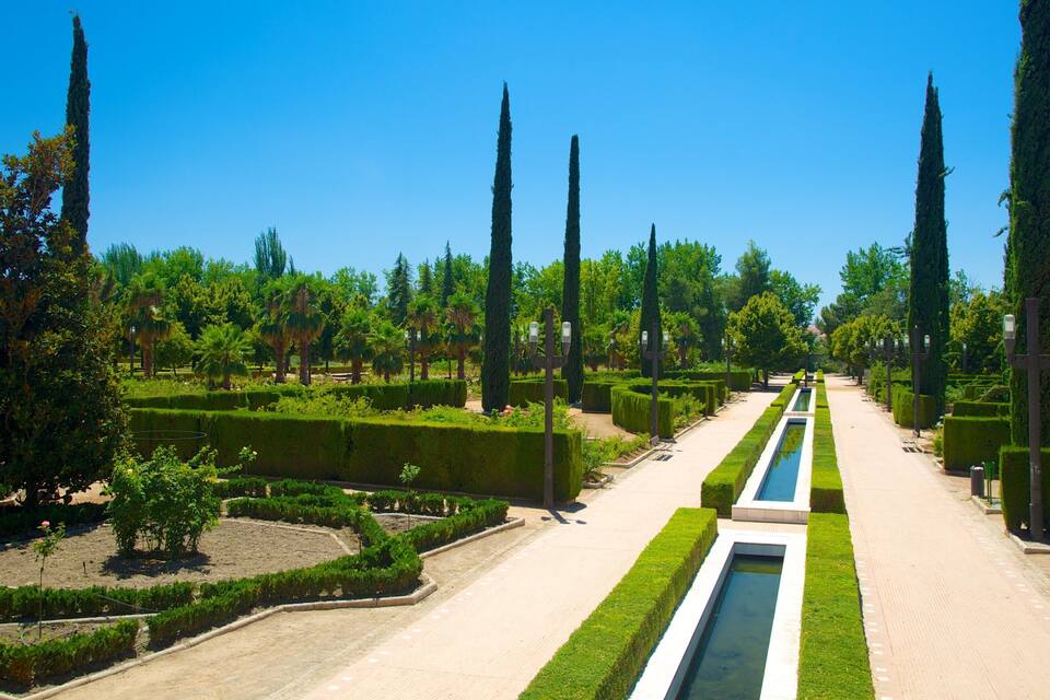 Ein formeller Garten mit geometrischen Hecken, hohen Zypressen und einem zentralen Wasserspiel.