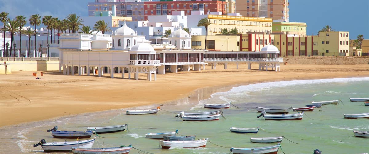 La Caleta Beach which includes a coastal town, a beach and boating