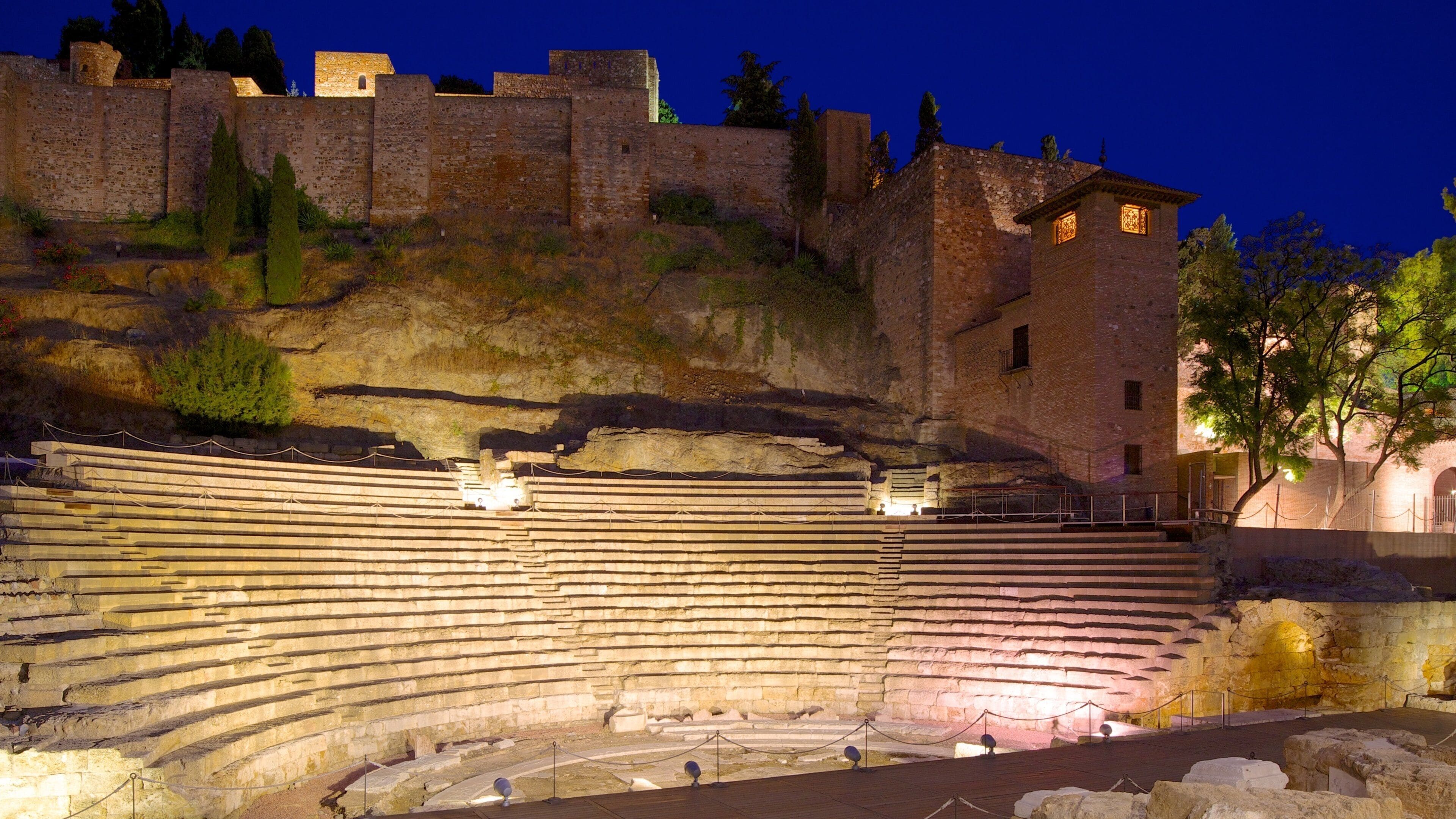 Malaga Amphitheatre showing heritage architecture, building ruins and night scenes