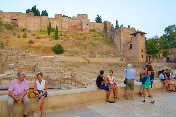 Malaga Amphitheatre featuring a ruin and heritage architecture as well as a large group of people