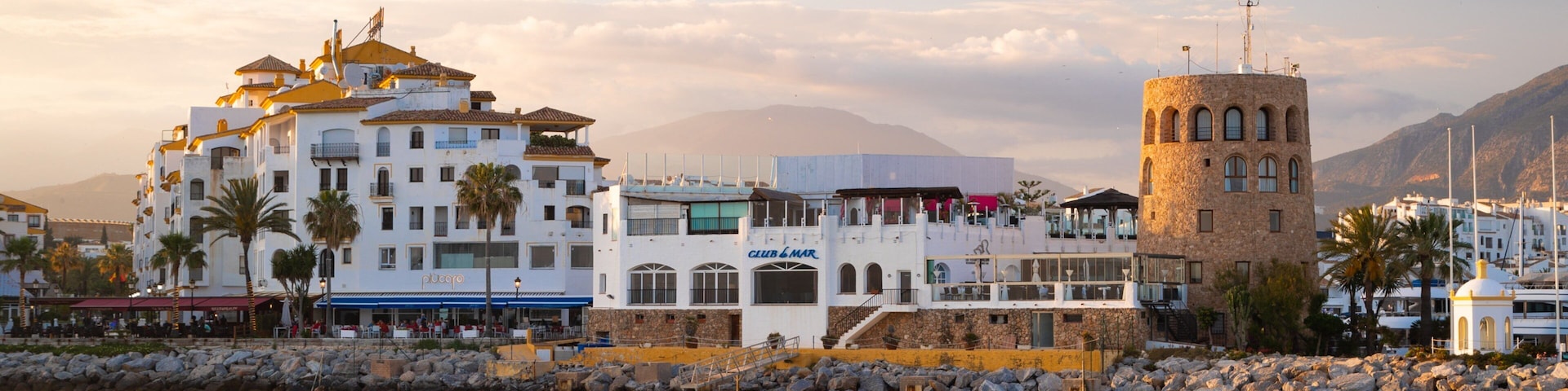 Puerto Banus Marina which includes a coastal town and a sunset