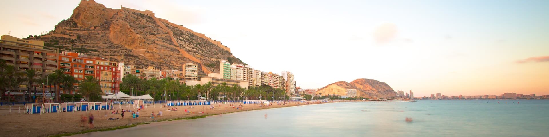 Postiguet Beach which includes a sunset, landscape views and a coastal town