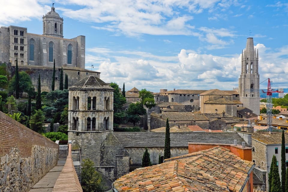 A historic town with a prominent church, a bell tower, and a small tower with arches.