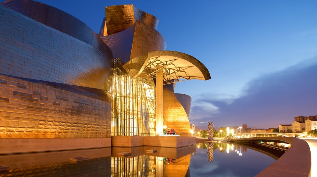 Guggenheim Museum Bilbao which includes night scenes, outdoor art and modern architecture
