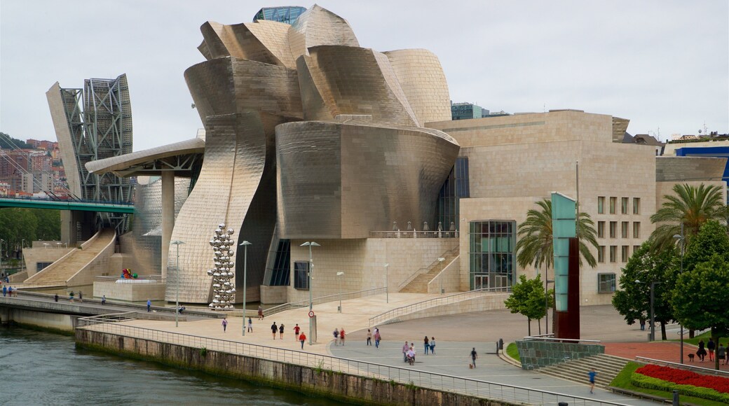 Guggenheim-Museum Bilbao das einen moderne Architektur und Fluss oder Bach sowie kleine Menschengruppe