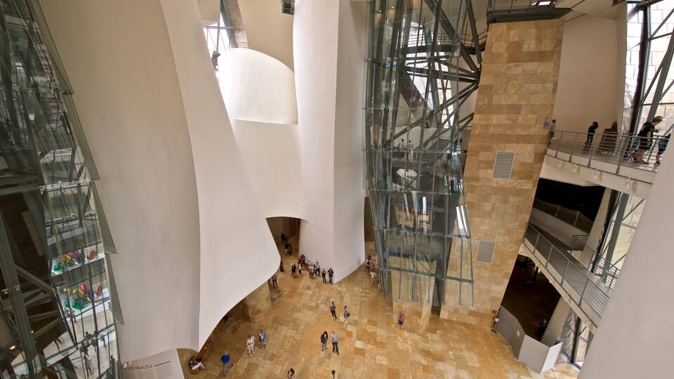 A modern architectural interior with glass staircases, a central white pillar, and a tiled floor.