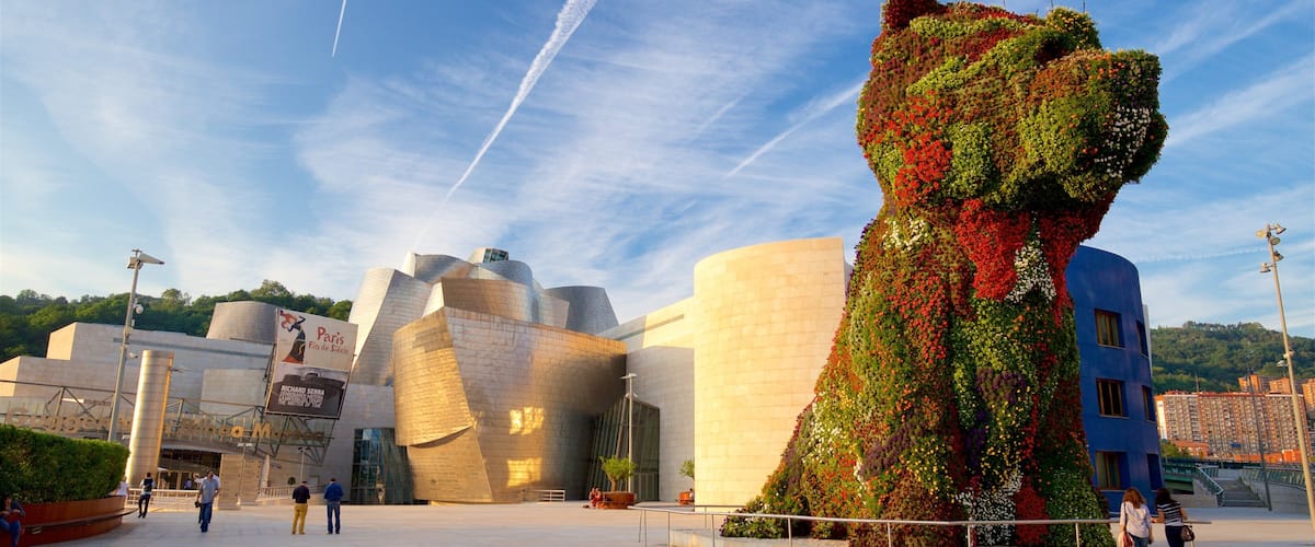 Museo Guggenheim de Bilbao que incluye una puesta de sol, arquitectura moderna y arte al aire libre