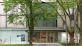 L’extérieur du musée des Beaux-Arts d’Ederren à Bilbao se distingue par sa façade moderne en verre, un grand arbre qui se trouve devant et un panneau d’affichage contenant des informations sur le musée.