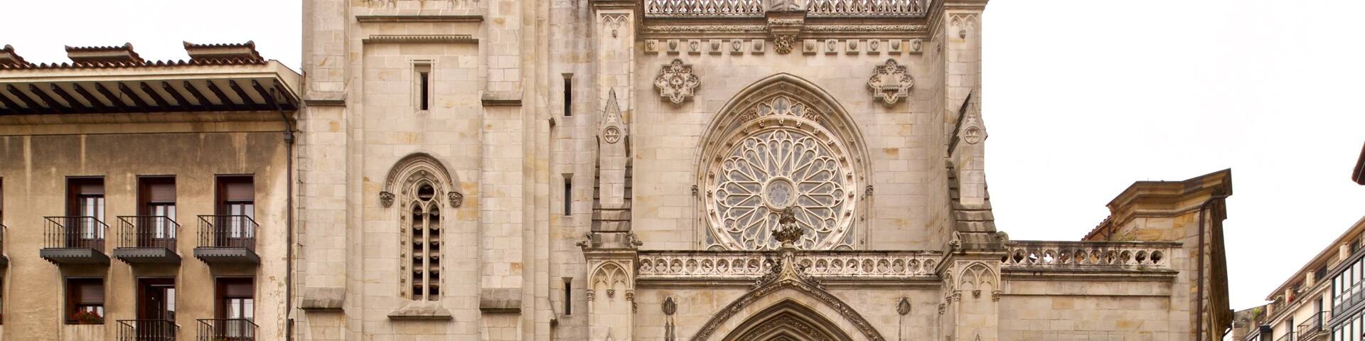 A historic cathedral with a large rose window and a clock on the tower.