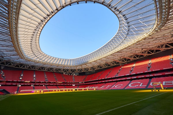 A large stadium with a circular roof and red seating.