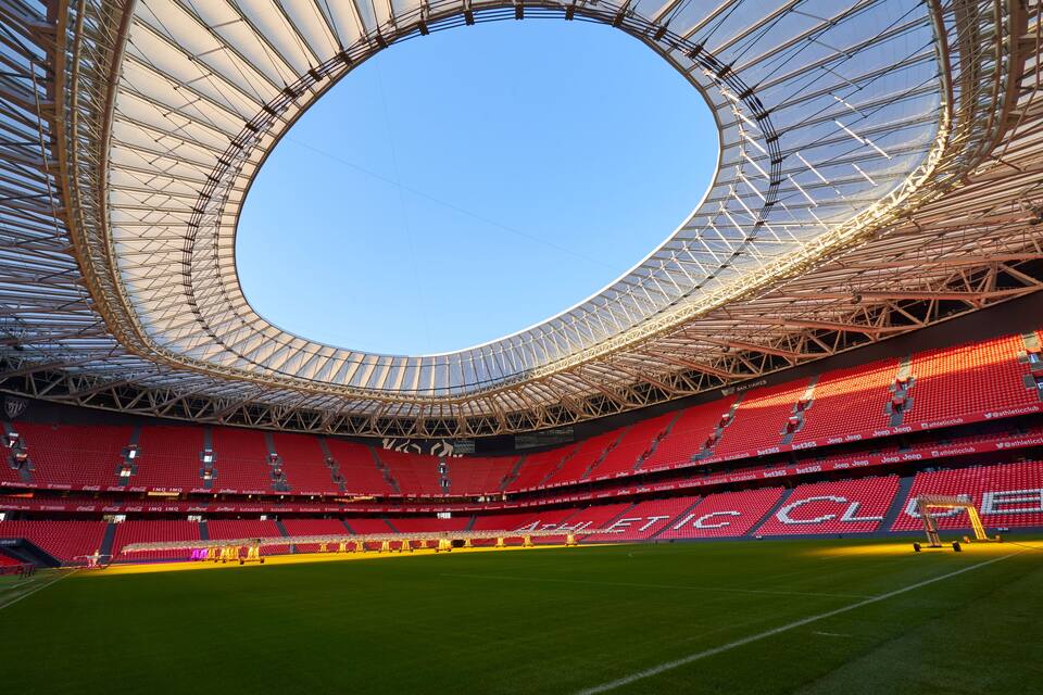 A large stadium with a circular roof and red seating.