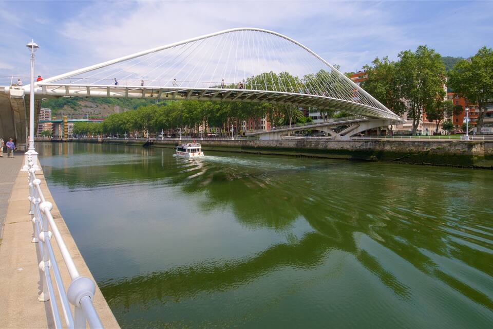 A river with a white bridge and a boat.