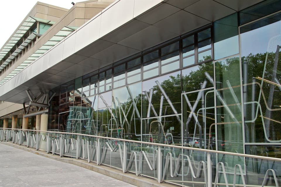A modern building with large glass windows and metal railings.
