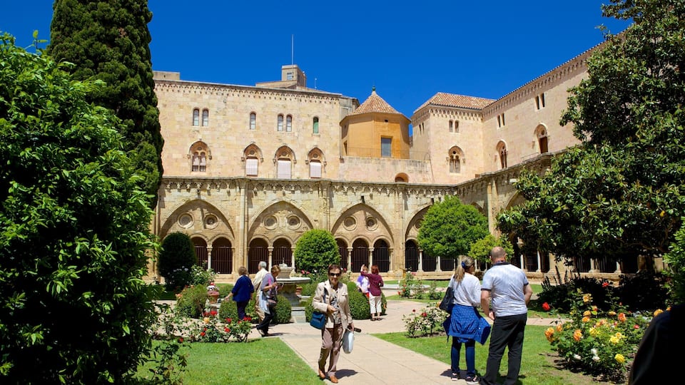 A historic courtyard with a large building featuring arched walkways and a central tower.
