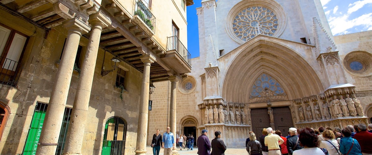 Catedral de Tarragona ofreciendo una iglesia o catedral y una plaza y también un grupo grande de personas