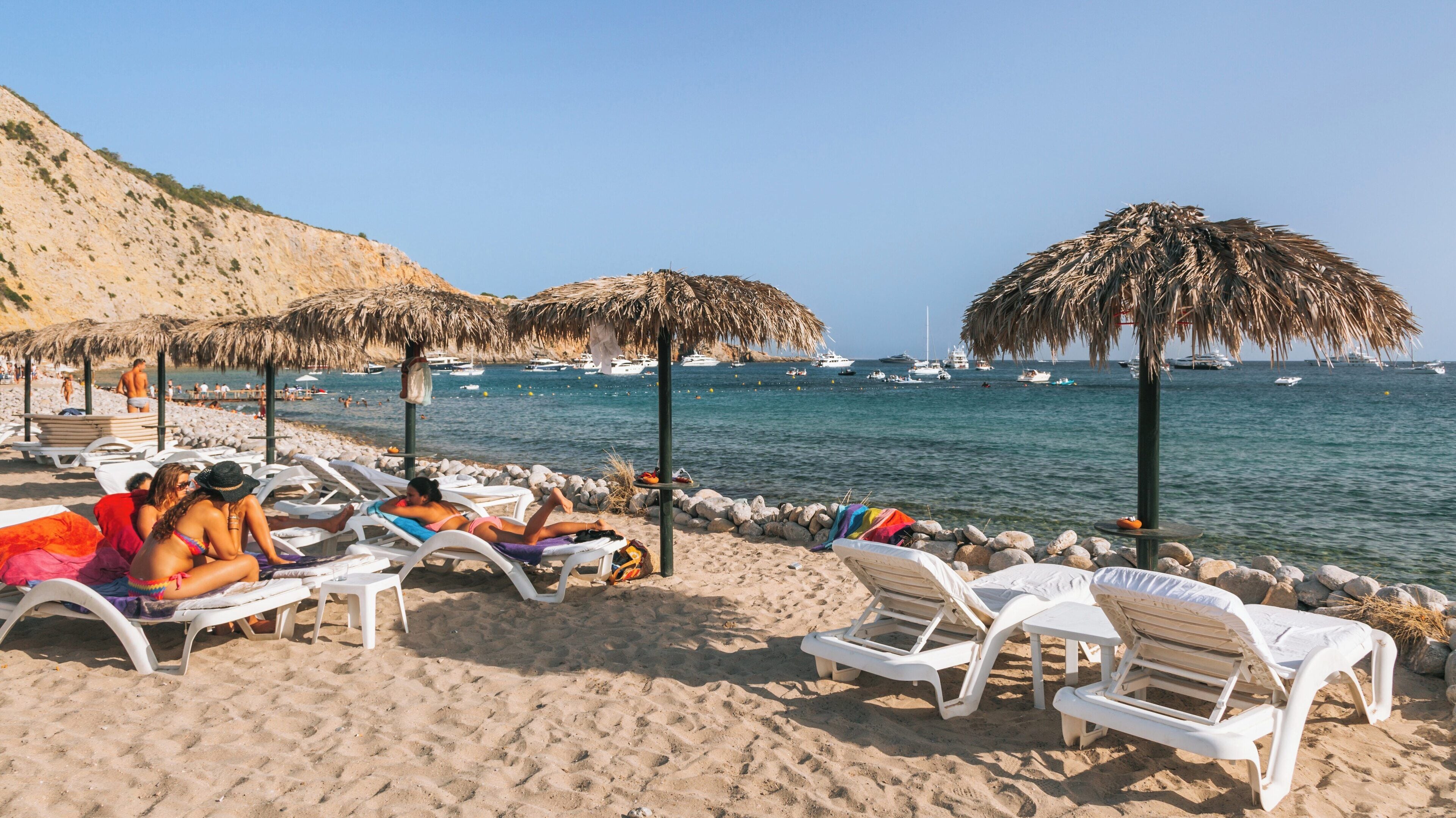 Relaxation and sunbathing at Cala Jondal Beach in Ibiza Town, Balearic Islands, Spain during a sunny day