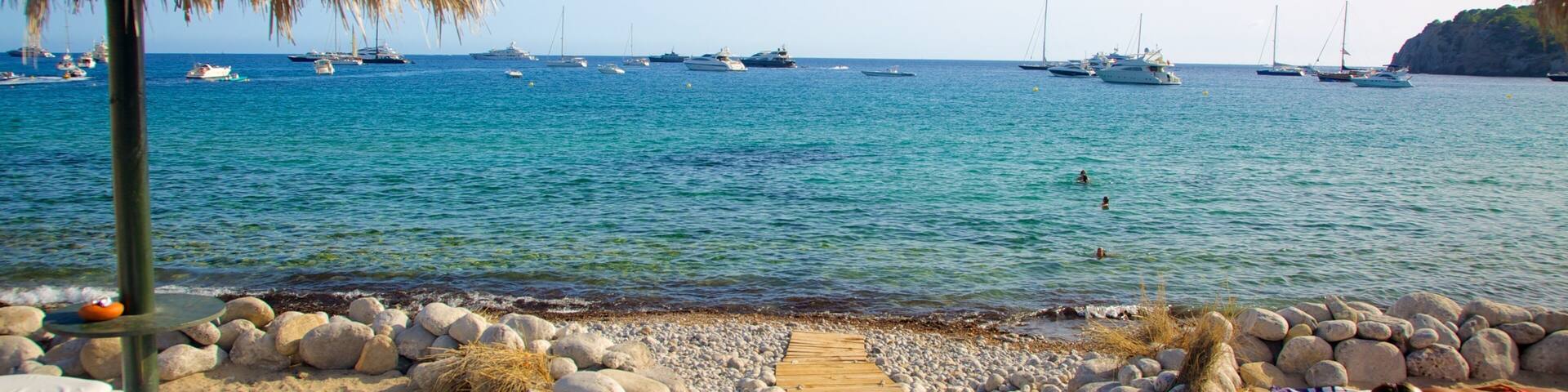 Cala Jondal Beach showing boating, a sandy beach and tropical scenes
