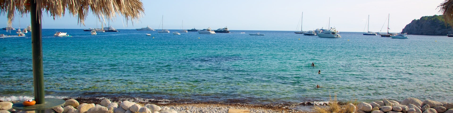 Cala Jondal Beach showing boating, a sandy beach and tropical scenes