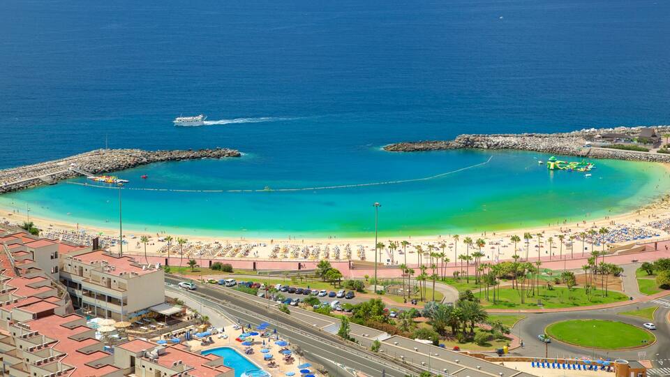 A coastal city with a beach, a marina, and a roundabout.