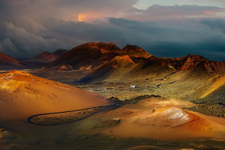 Wüstenlandschaft mit markanten Sanddünen und felsigen Bergen unter einem beeindruckenden Himmel.