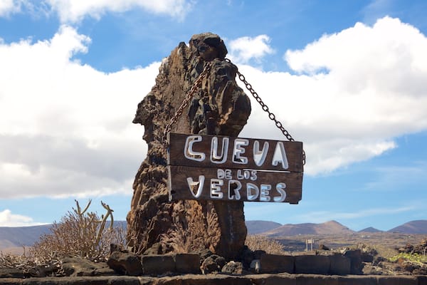 A large rock formation with a sign reading "Cueva de los Verdes".