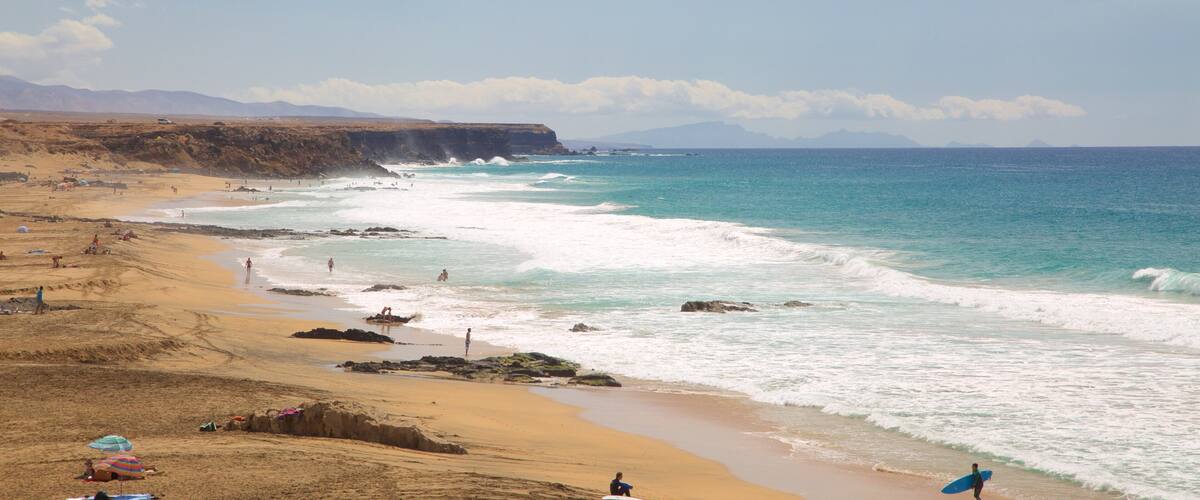 Cotillo Beach featuring a sandy beach, surf and rocky coastline