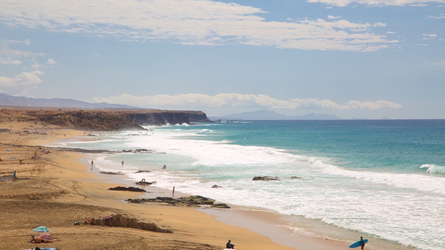 Cotillo Beach featuring a sandy beach, surf and rocky coastline