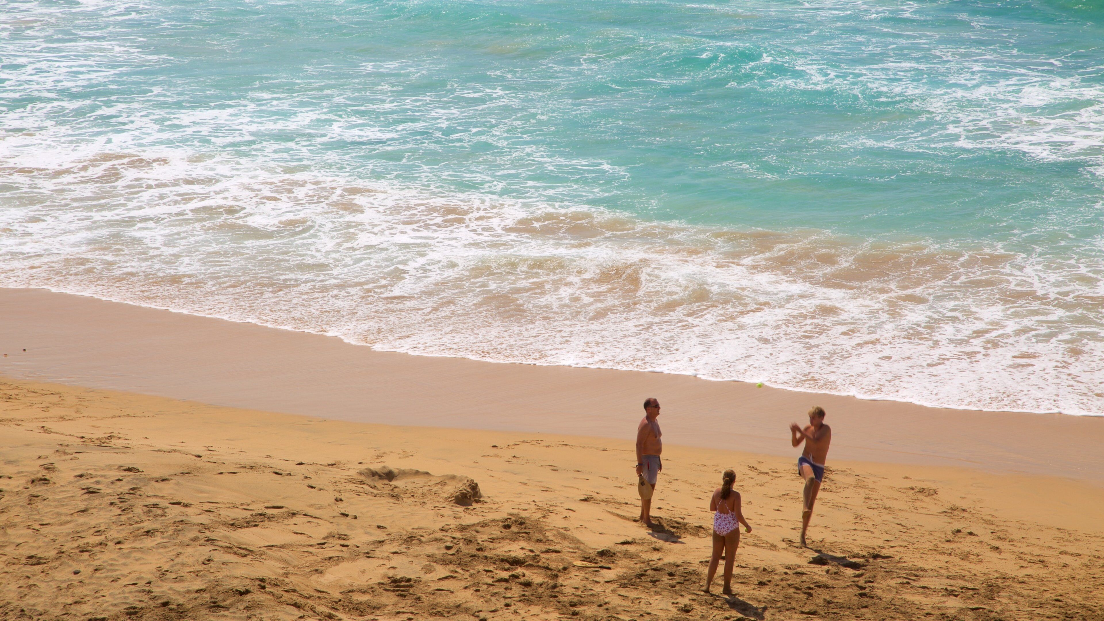 Playa del Cotillo ofreciendo vista general a la costa y una playa y también un pequeño grupo de personas