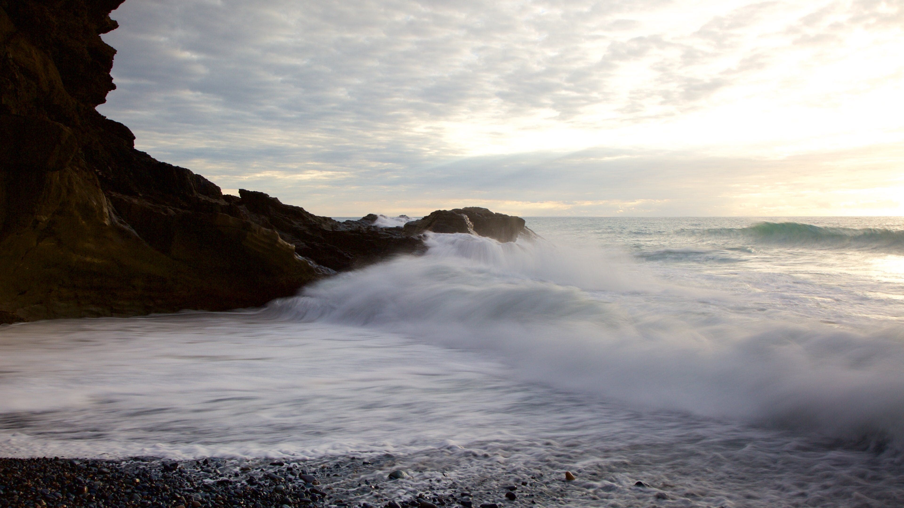 Ajuy Beach showing rugged coastline, a pebble beach and surf