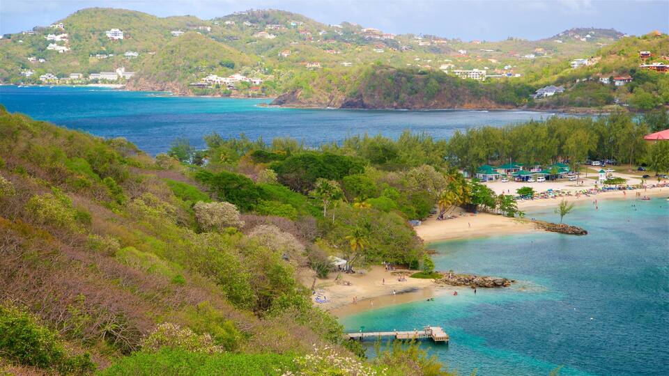 A coastal landscape with a beach, clear turquoise waters, and lush greenery.