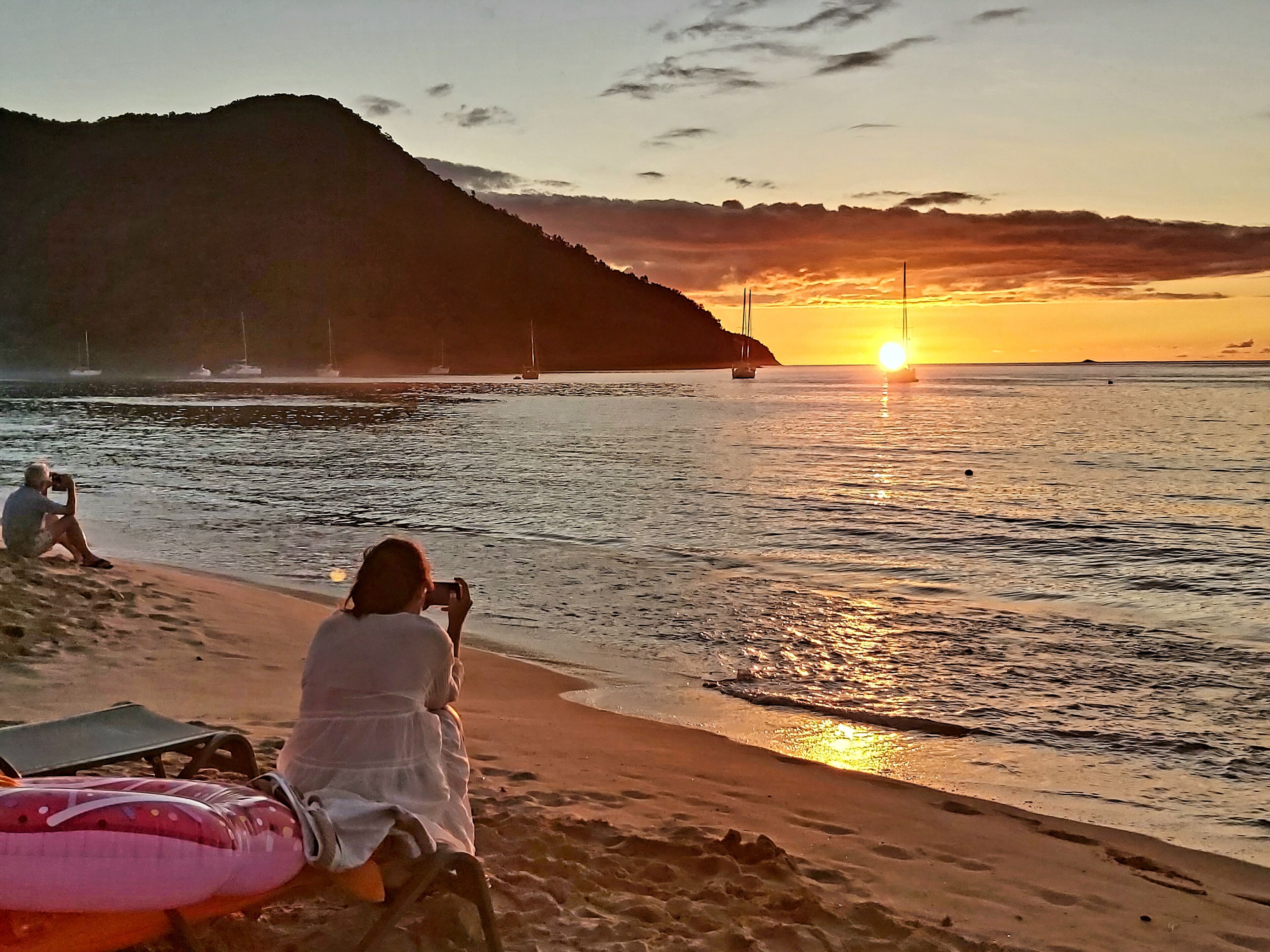 Sunset shooters. Photographers capture the setting sun, with wisps of smoke from a beach bbq drifting across the bay.  #sunset #beach #reduitbeach #stlucia #caribbean #trovember #outdoors