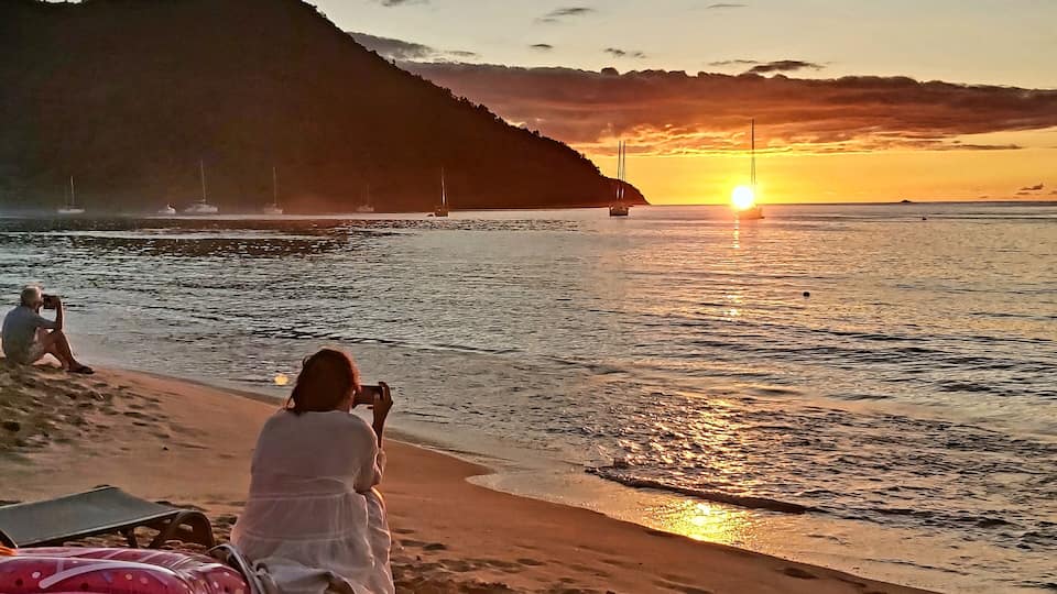 Sunset shooters. Photographers capture the setting sun, with wisps of smoke from a beach bbq drifting across the bay. #sunset #beach #reduitbeach #stlucia #caribbean #trovember #outdoors