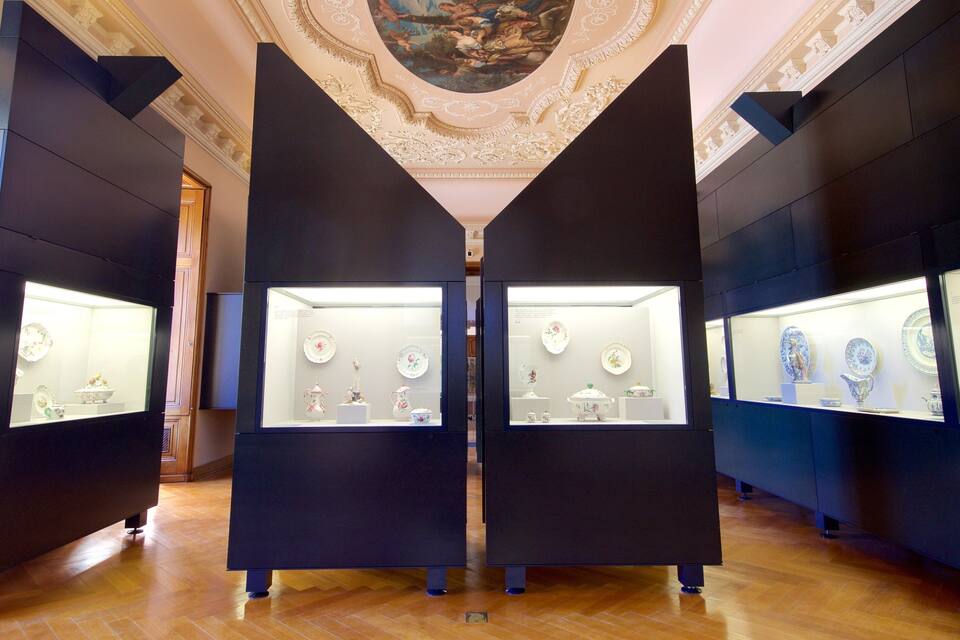 A museum interior with glass display cases containing porcelain items.