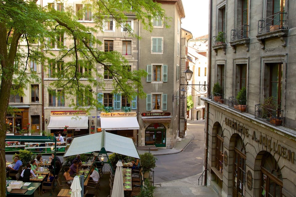 A bustling street with outdoor cafes, historic buildings, and a tree-lined avenue.