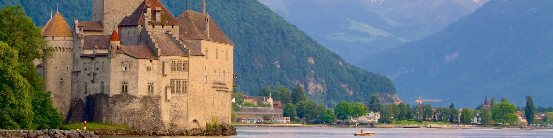Chateau de Chillon which includes a castle, a lake or waterhole and mountains