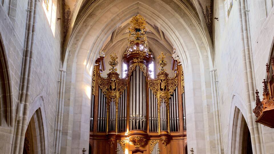 An ornate church interior with a large pipe organ, arched ceilings, and detailed woodwork.