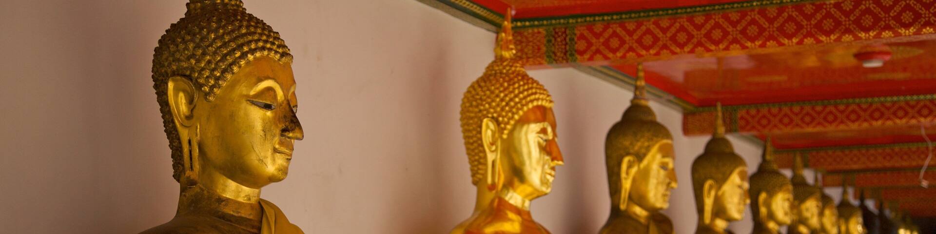 Detailed view of golden Buddha statues at Wat Pho in Bangkok highlighting Thai culture and spirituality
