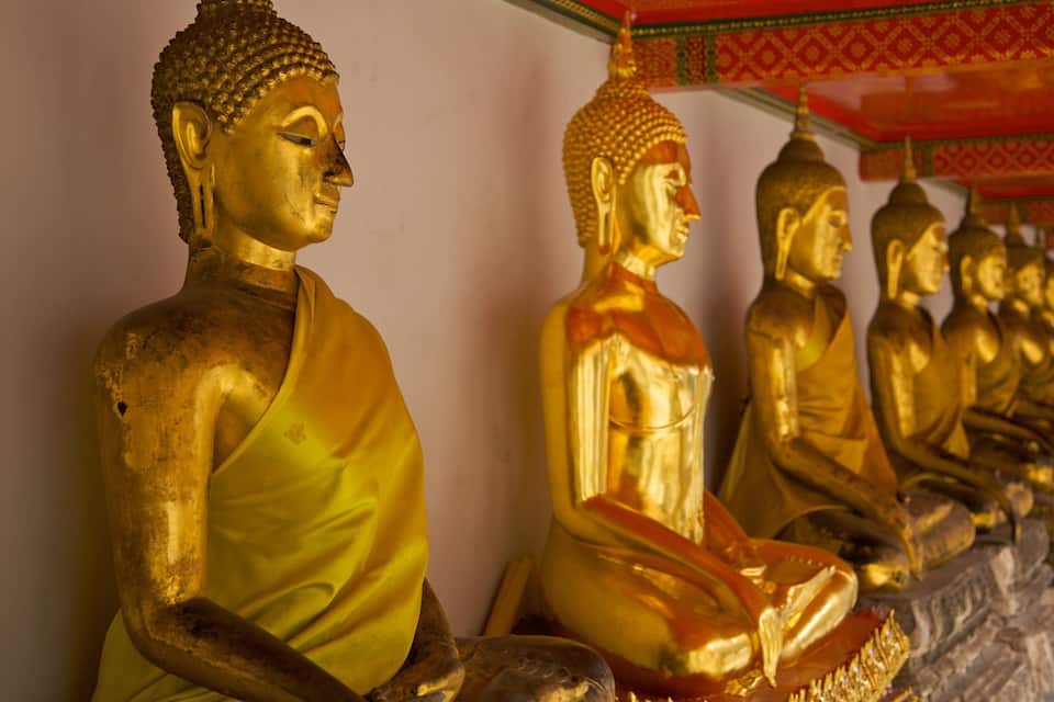 A row of golden Buddha statues in a temple.