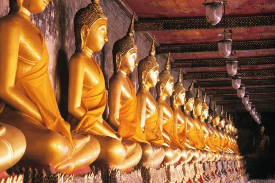 A row of golden Buddha statues in a temple.