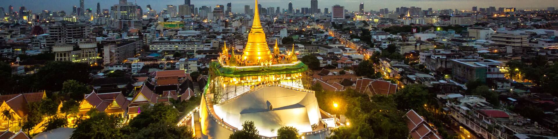 A cityscape with a prominent golden spire and a large temple complex.