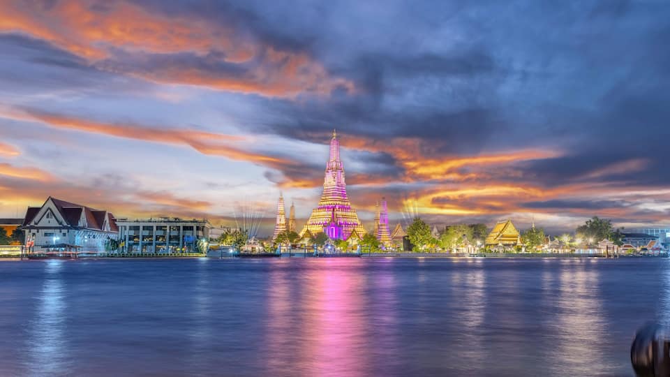 26 November 2025 Beautiful Sunset colours of Thai Temple Wat Arun on Chao Phraya River in BKK Bangkok Thailand. The magic colourful neon light display on the temple at sunset is magical.