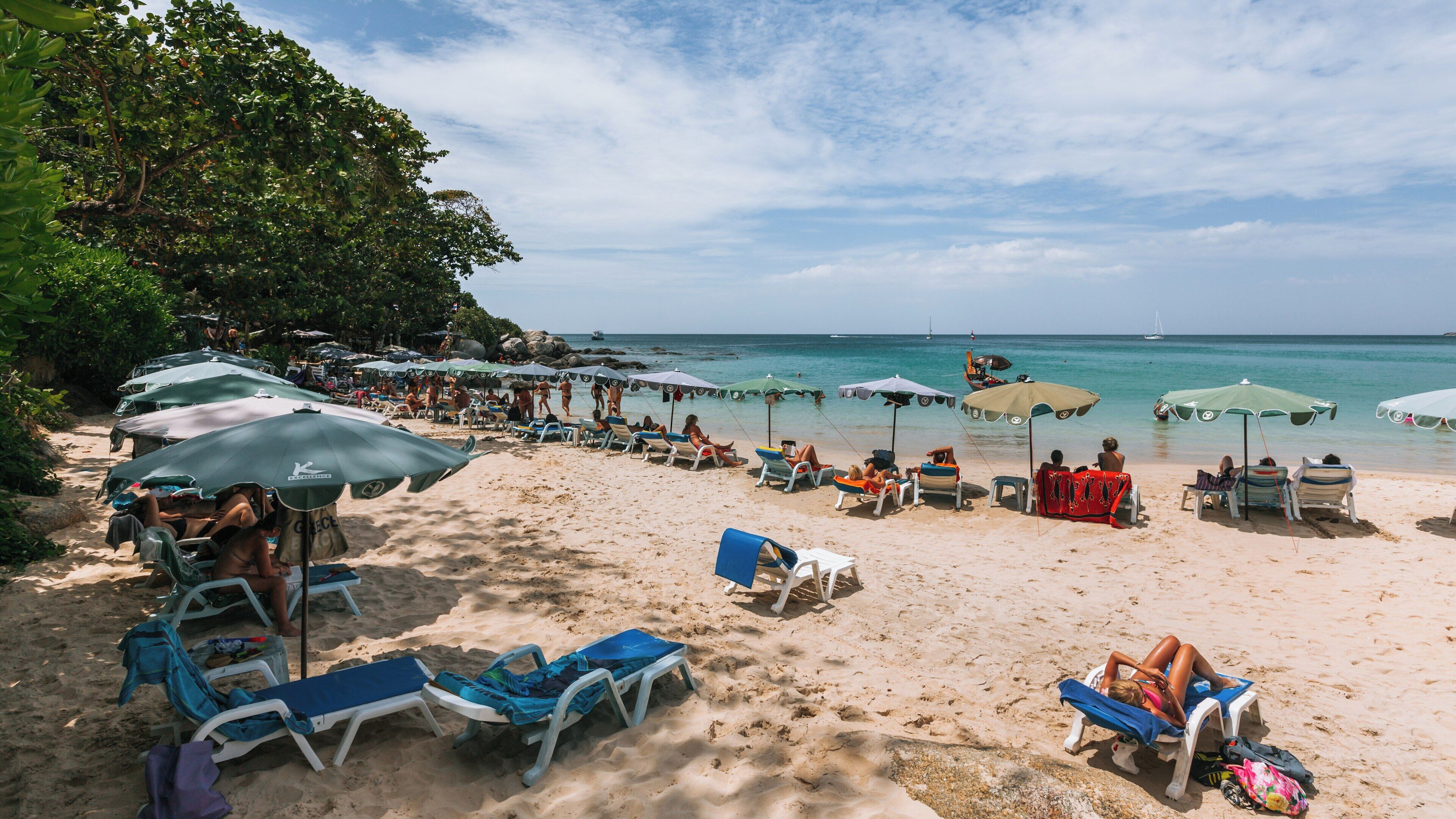 Relaxation and leisure at Kata Noi Beach in Phuket, Thailand with sunbeds and umbrellas on a clear day