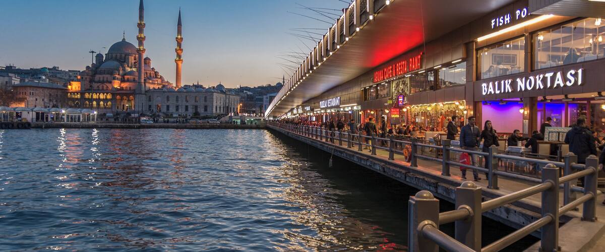 Dining on Galata Bridge at night with New Mosque in the background,Eminonu,Istanbul,Turkey