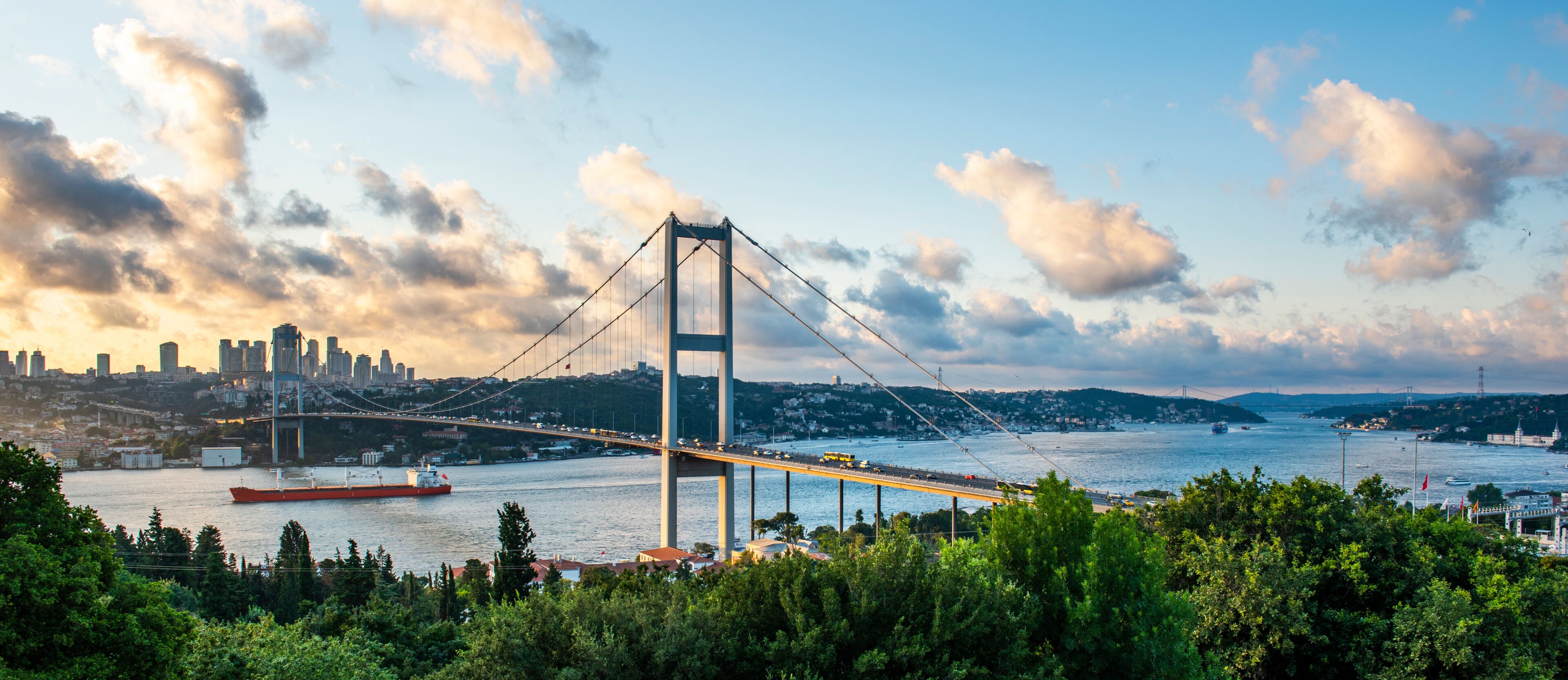 ISTANBUL, TURKEY. Panoramic view of Istanbul Bosphorus on sunset. Istanbul Bosphorus Bridge (15 July Martyrs Bridge. Turkish: 15 Temmuz Sehitler Koprusu). Beautiful cloudy blue sky.